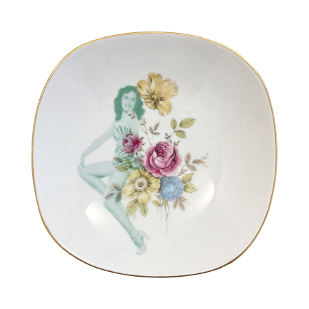 Vintage schaaltje met verfijnde bloemen in roze, blauw en geel, bedrukt met een szittend fotomodel in groen raster